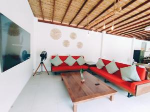 sala de estar con sofá rojo y mesa de madera en Superb pool villa 5 bedrooms, en Baan Tai