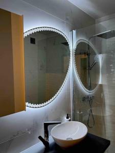 y baño con lavabo y espejo. en Le lys - Cosy et atypique à Moulin-Les-Metz, en Moulins-lès-Metz