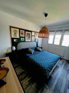 ein Schlafzimmer mit einem blauen Bett in einem Zimmer in der Unterkunft Le lys - Cosy et atypique à Moulin-Les-Metz in Moulins-lès-Metz