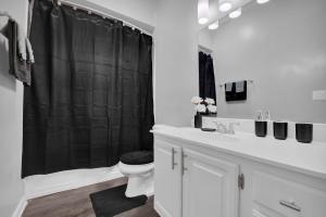 een badkamer met een zwart douchegordijn en een toilet bij 1 BR 1 BA Stylish Apartment in Brookhaven in Atlanta