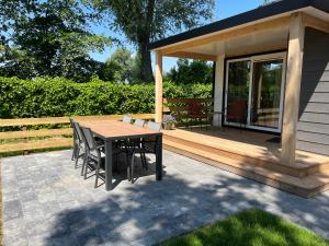a table and chairs on a patio with a gazebo at Vakantiehuis 6 personen in Opheusden