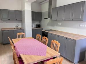 cocina con mesa de madera con sillas, mesa y barra en Penzion Hají en Janov nad Nisou