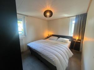 a bedroom with a bed with a light on the ceiling at Vakantiehuis 6 personen in Opheusden