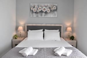 a bedroom with a large white bed with two pillows at Salt and petals in Samothráki