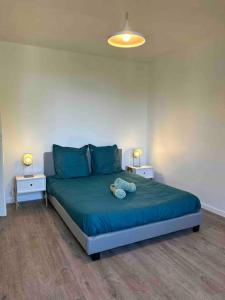 1 dormitorio con 1 cama con sábanas azules y 2 lámparas en Le St Martin Appart', en Coligny