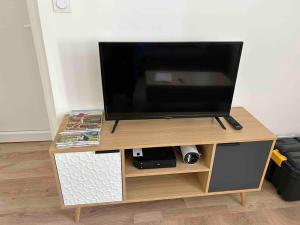 a flat screen tv sitting on top of a wooden stand at Le St Martin Appart' in Coligny