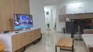 a living room with a flat screen tv on a cabinet at Apartman 3 BMB in Veliko Gradište