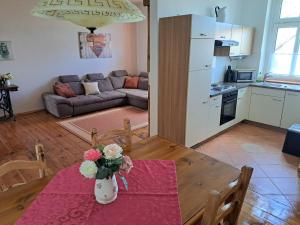 una cucina e un soggiorno con tavolo e fiori di Ferienhof Schönberg a Lindow