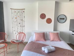 um quarto com uma cama com almofadas e cadeiras cor-de-rosa em St Paul Resort em Safra