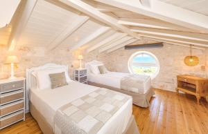 two beds in a room with a window at The Yiameli Collection - Meli in Skinária