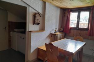 cocina con mesa de madera en una habitación en Studio in the center of the village en La Clusaz