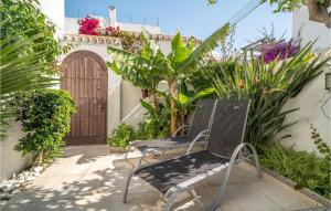 une paire de chaises sur une terrasse avec une porte en bois dans l'établissement Gorgeous Home In Estepona With Kitchen, à Estepona