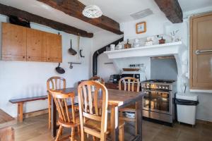 a kitchen with a table and chairs and a stove at Véritable Mas Provençal À La Palud in La Palud sur Verdon