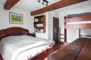 een slaapkamer met een houten bed en een houten tafel bij Véritable Mas Provençal À La Palud in La Palud sur Verdon