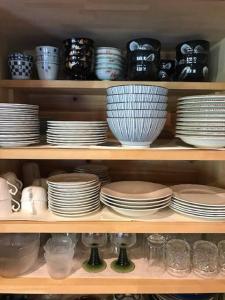 a shelf filled with plates and bowls and dishes at ビラ里山双林 in Inashiki