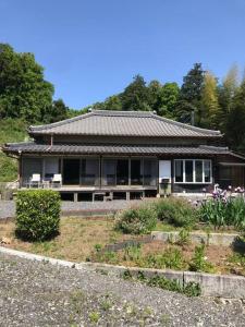 a house with a roof on top of a yard at ビラ里山双林 in Inashiki