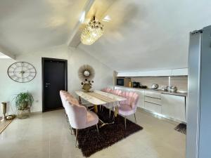 a dining room with a table and pink chairs at Apartments Kentera LUX in Sveti Stefan