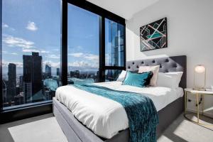 een slaapkamer met een groot bed en een groot raam bij Stunning City Views 2 bed 2 bath- Ur Urban Oasis！ in Melbourne