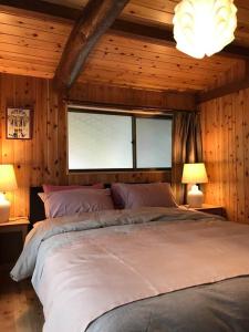 una camera con un grande letto con due lampade di ビラ里山双林 a Inashiki