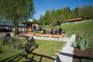 eine Gruppe von Menschen, die auf einer Bank auf einem Hof sitzen in der Unterkunft B&B Mad Mountain in Robidišče