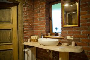 a bathroom with a sink and a brick wall at Знакова Хата in Grebenov +50 photos