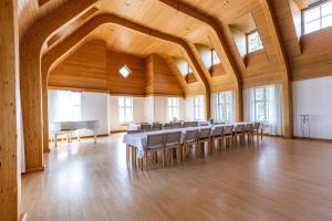 Cette grande chambre est dotée de plafonds en bois, de tables et de chaises. dans l'établissement Hotelli Siuntio, à Sjundeå