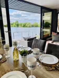 - une table avec des assiettes et des verres à vin sur un bateau dans l'établissement Hausboot La Mare Gabi, à Weyhe