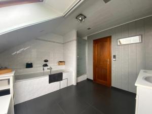 uma casa de banho com um lavatório e uma banheira em Hébergement à 20 min à pied du circuit Spa-Francorchamps em Malmedy