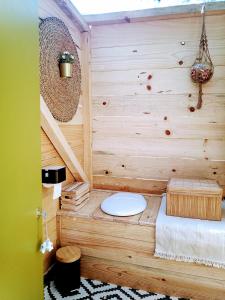 a bathroom with a toilet in a wooden wall at Verde Água Agroturismo e Agricultura Biológica in Couto