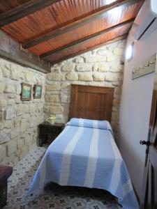 een slaapkamer met een bed in een stenen gebouw bij La alegria de las cuevas in Rus