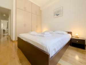 a bedroom with a large bed with white sheets at Mezonos Modern 65sqm apt in Athens in Athens