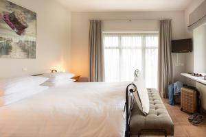 - une chambre avec un grand lit blanc et une fenêtre dans l'établissement Landhotel Teichwiesenhof, à Oldenbourg en Holstein
