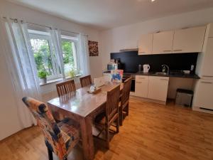 a kitchen with a wooden table and chairs in a room at Cozy Nest in Salzburg