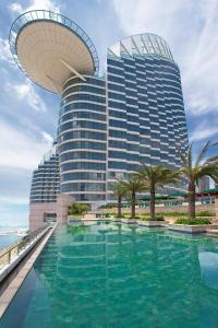 a large building with a swimming pool in front of it at Sheraton Zhanjiang Hotel in Zhanjiang