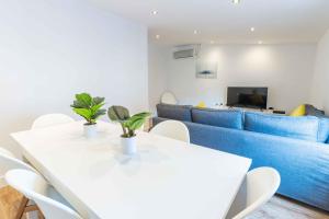 a living room with a blue couch and a table and chairs at Reial 4 Tarragona in Tarragona