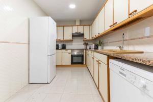 uma cozinha com electrodomésticos brancos e um frigorífico branco em Reial 4 Tarragona em Tarragona