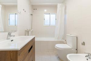 a white bathroom with a sink and a toilet at Reial 4 Tarragona in Tarragona