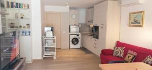 een woonkamer met een rode bank en een keuken bij RosMarino_Appartamento Fronte Mare in Roseto degli Abruzzi