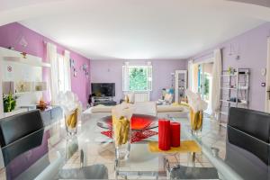 ein Wohnzimmer mit lilafarbenen Wänden sowie einem Tisch und Stühlen in der Unterkunft La Calanque in Marseille