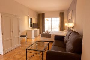 sala de estar con sofá y cama en Dunas de Doñana Resort en Matalascañas