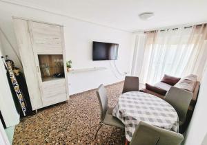 a living room with a table and a couch and a television at Carmen Apartments in Benidorm