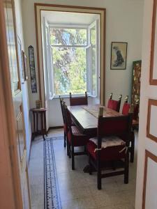 ein Esszimmer mit Tisch und Stühlen und einem Fenster in der Unterkunft Villa Giuseppina Miramare in San Menaio
