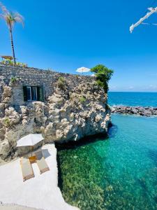 eine Gruppe von Stühlen und Sonnenschirmen am Strand in der Unterkunft Pagoda Lifestyle Hotel in Ischia