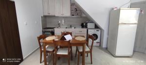 una cucina con tavolo, sedie e frigorifero di Xenonas "Alexandra's Coffee House" a Volímai