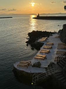 a row of tables in the water at sunset at Pagoda Lifestyle Hotel in Ischia