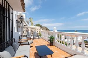 balkon z krzesłami i widokiem na ocean w obiekcie Casa Siloam w mieście Torrox Costa