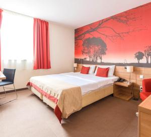 a hotel room with a bed and a red painting on the wall at Expo Congress Hotel in Budapest