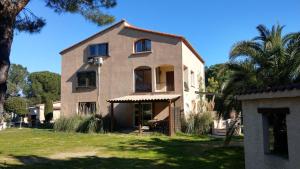 a house with a palm tree in front of it at Cigale 2 in Argelès-sur-Mer