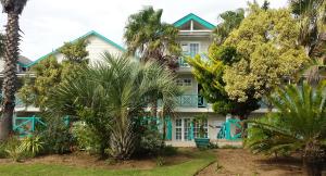 una casa blu e bianca con palme di fronte di Halyards Hotel a Port Alfred