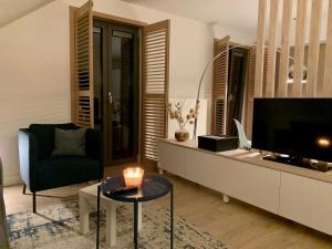 a living room with a tv and a chair and a table at Bonne Suite Chambre d'Hotes in Rekem